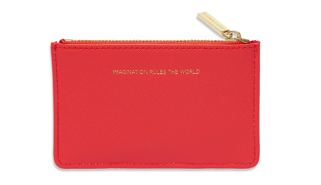 Coral coloured card wallet with gold zipper detailing and gold embossed writing reading "Imagination rules the world"on the front