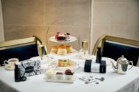 Afternoon tea set up on a white tablecloth with tarot cards.