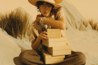Woman sitting on the beach surrounded by boxes