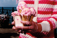 Jo Malone raspberry ripple fragrance being held in a woman's hand alongside three dripping pink ice creams.