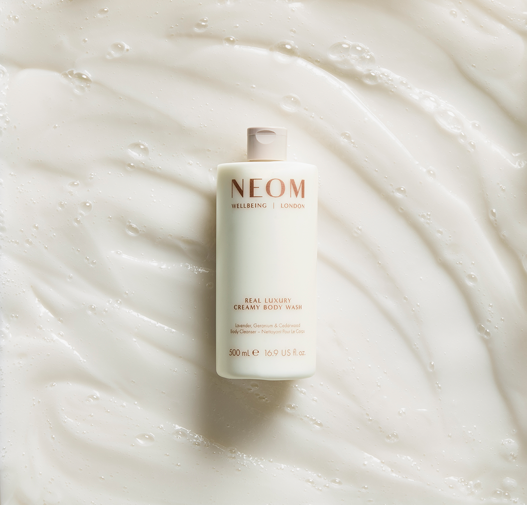 Neom body wash bottle on white textured background
